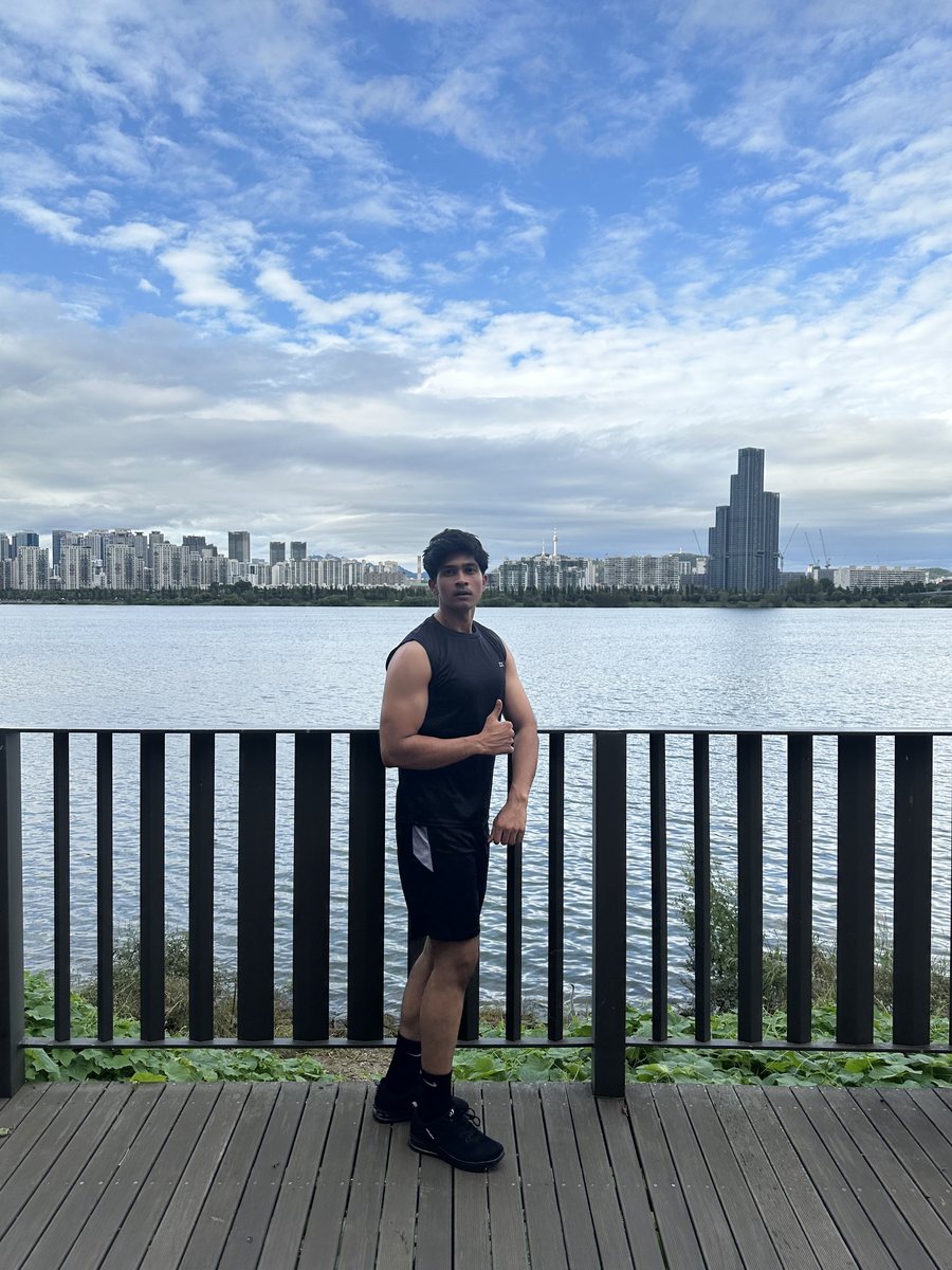 Ayush Patel working out by the Han River with the Seoul city skyline behind